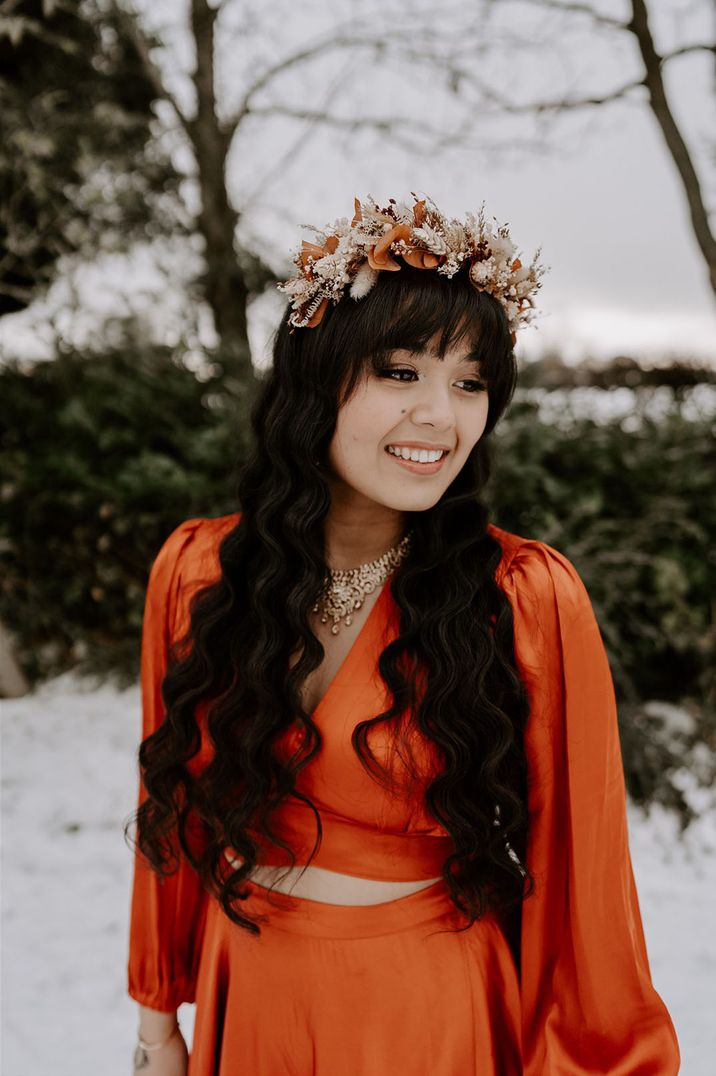 Bride with mermaid wavy hair in a red wedding dress with a boho dried flower crown 