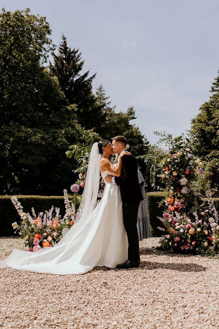 Bride and groom share a kiss at their outdoor wedding ceremony at Wootton Hall 