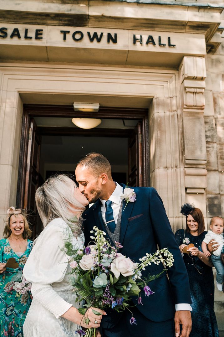 Bride in a highstreet wedding dress kissing her groom outside their Intimate Sale Registry Office wedding 