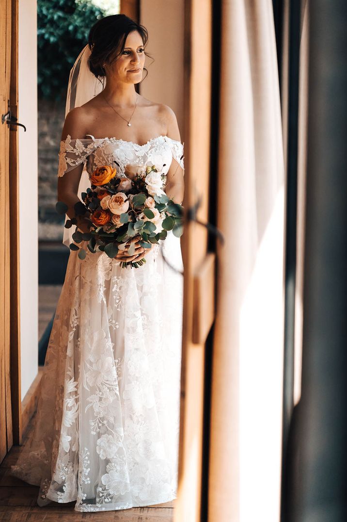 Bride in a lace wedding dress with an off the shoulder detail 