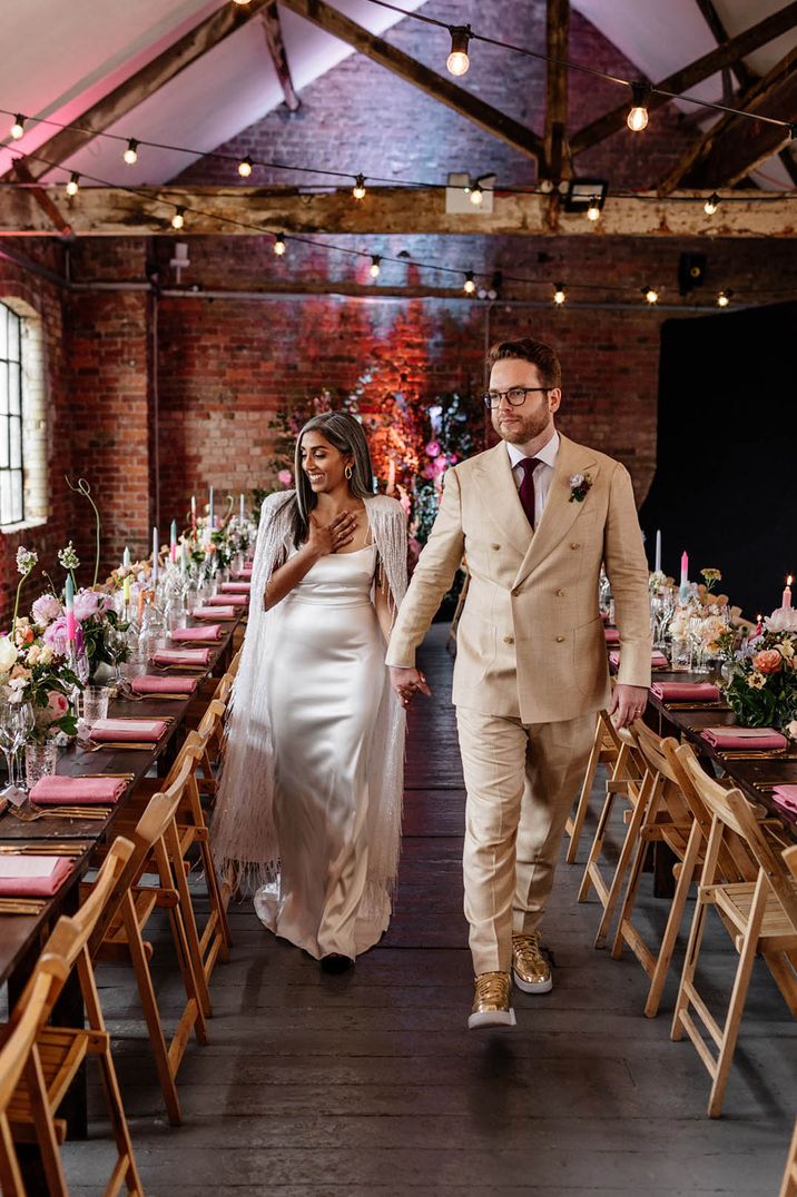 Loft Studios wedding under 40k with the bride and groom walking into their wedding reception with a pastel colour palette 