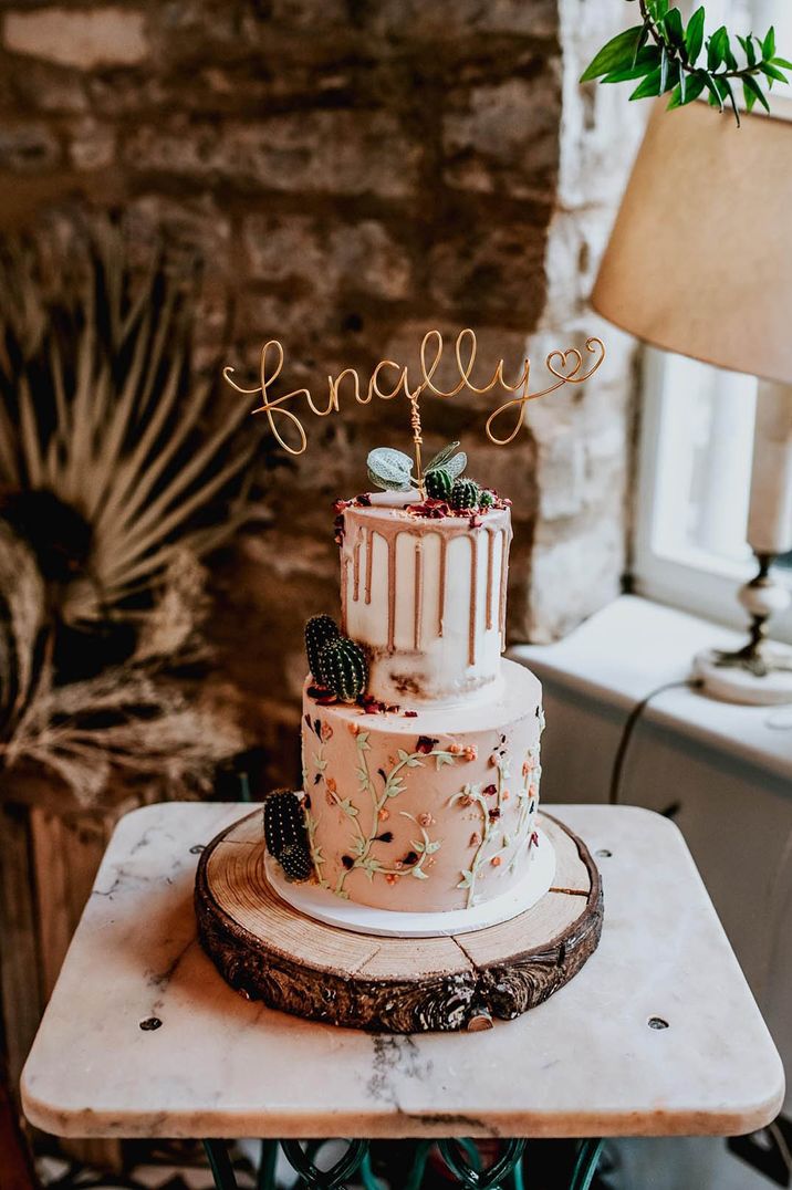 two tier drip wedding cake with wire cake topper