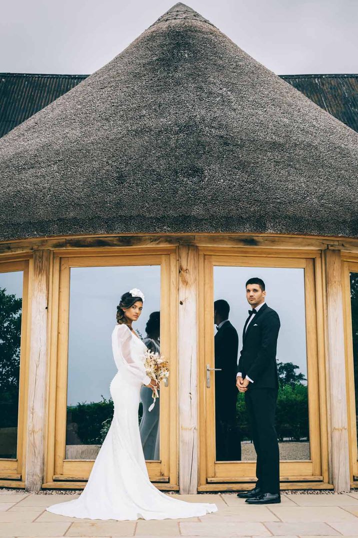 Bride and groom standing outside Brickhouse Vineyard wedding venue Devon