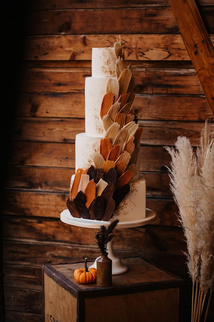 Epic foru tier wedding cake with deep autumnal colours in orange, brown, and beige shades 