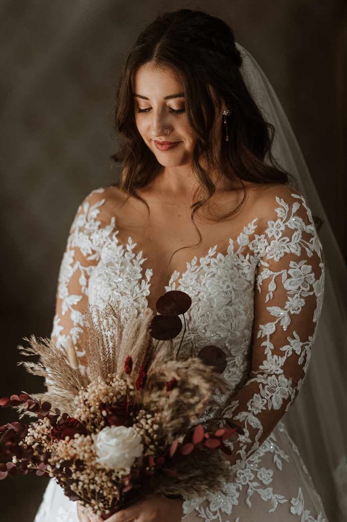 Bride in stunning illusion long sleeve wedding dress with dried flower wedding bouquet with pampas grass and bunny grass 