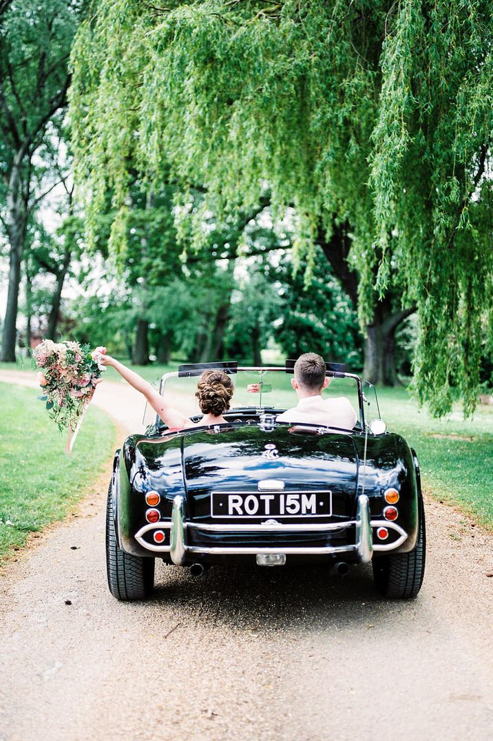 Black convertible wedding car in with pink florals