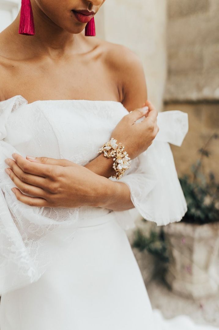 Bride wearing a metal cuff wedding bracelet with vines and flower design 