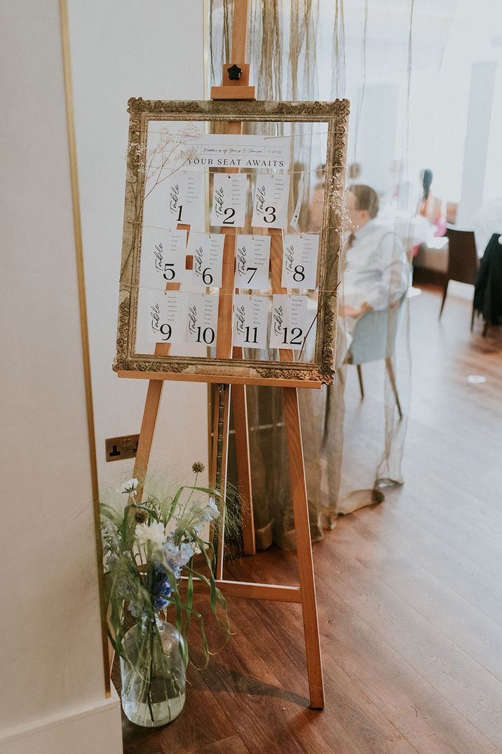 Gold vintage photo frame with string and card seating chart with dried flower decor 