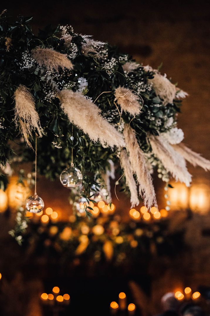 The festive foliage decorated with pampas grass and hanging baubles for winter wedding 