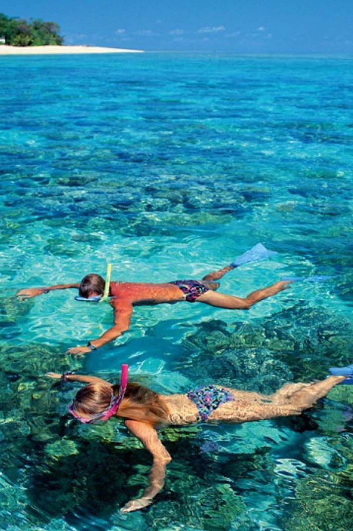 People snorkelling on holiday in hot and exotic country 