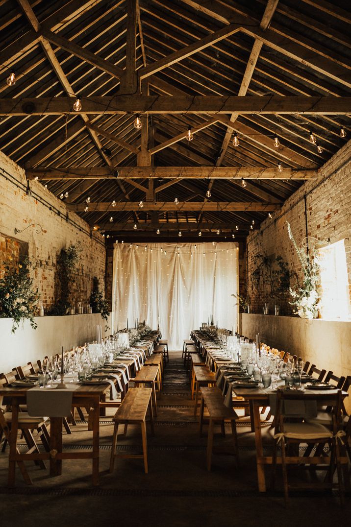 Boho wedding at Fishkey Hall, Norfolk with banquet tables and festoon lights decor 