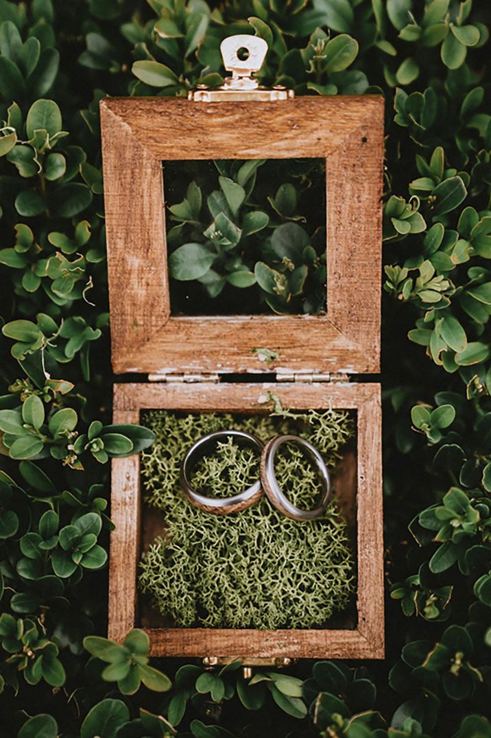 Golden wedding rings in wooden box with moss decorations