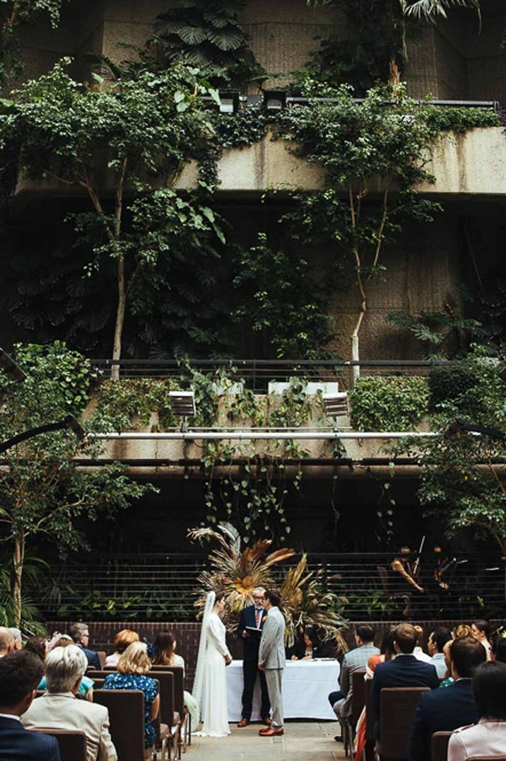 Bride and groom standing at the alter at The Barbican Conservatory glasshouse wedding venue 