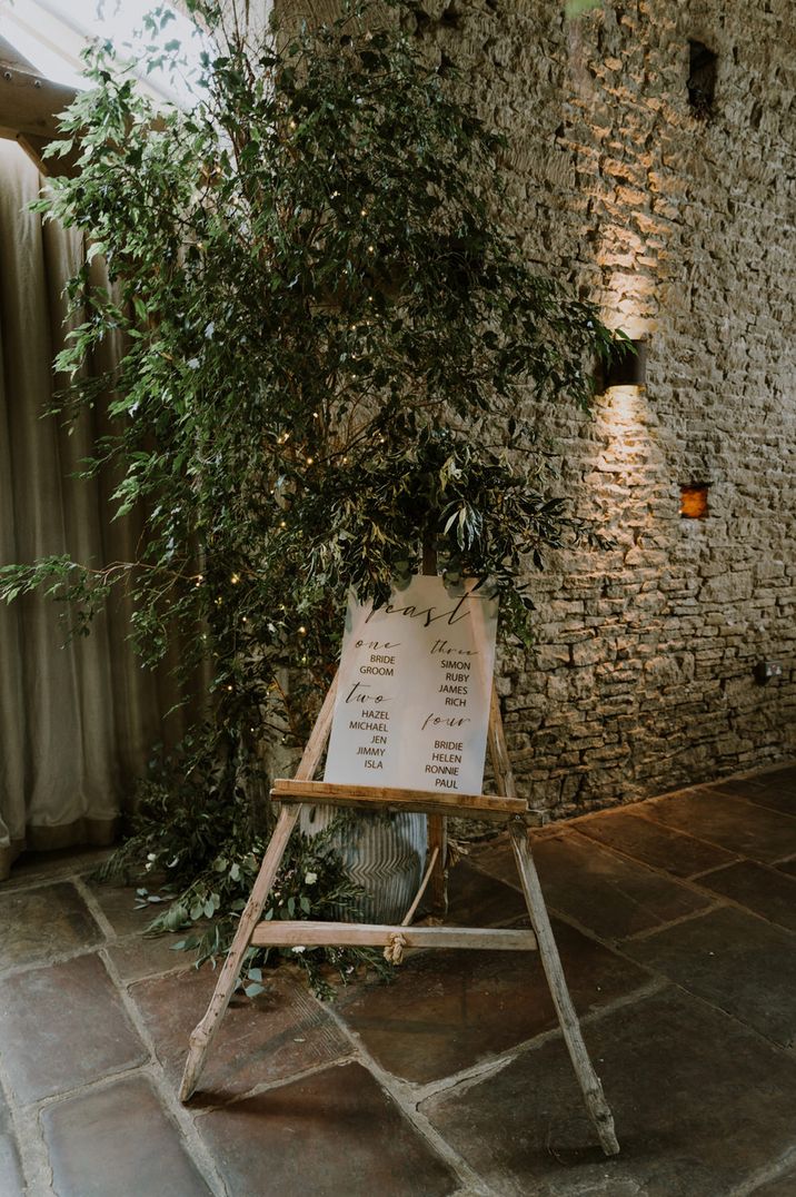 Table plan on a wooden easel decorated with foliage 