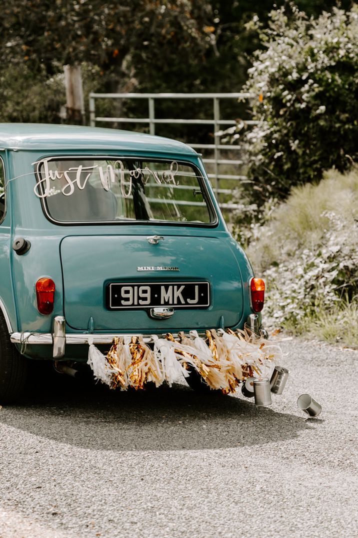 Aqua blue vintage wedding car with streamers and "Just Married" banner 