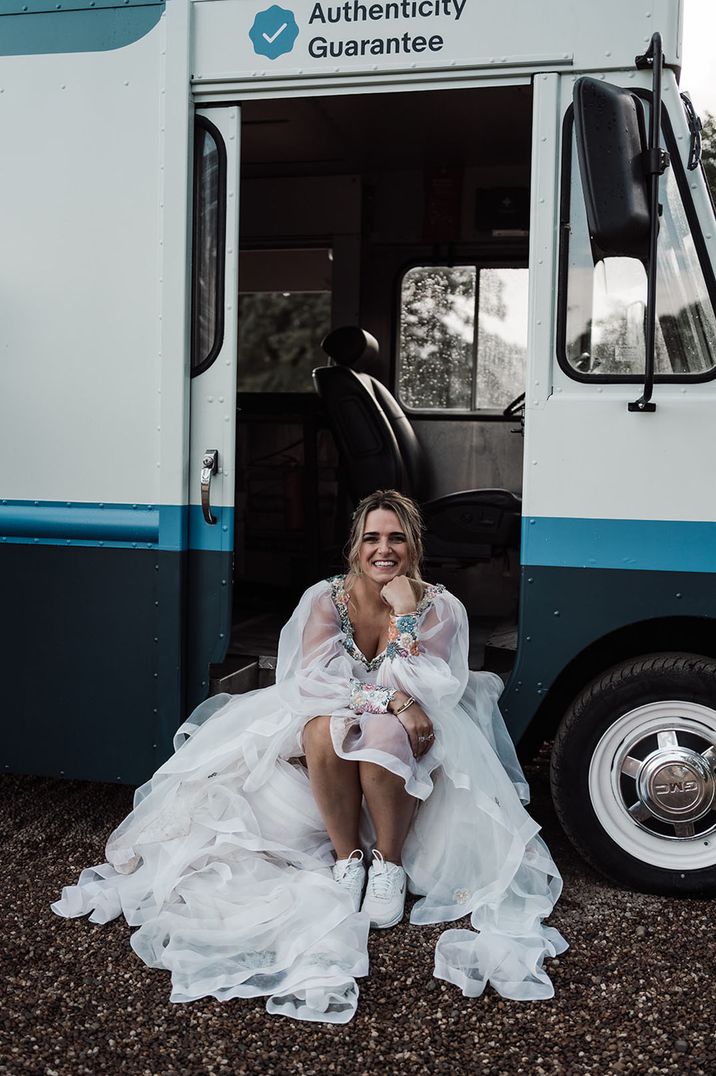 Bride wears appliqué wedding dress and white trainers 