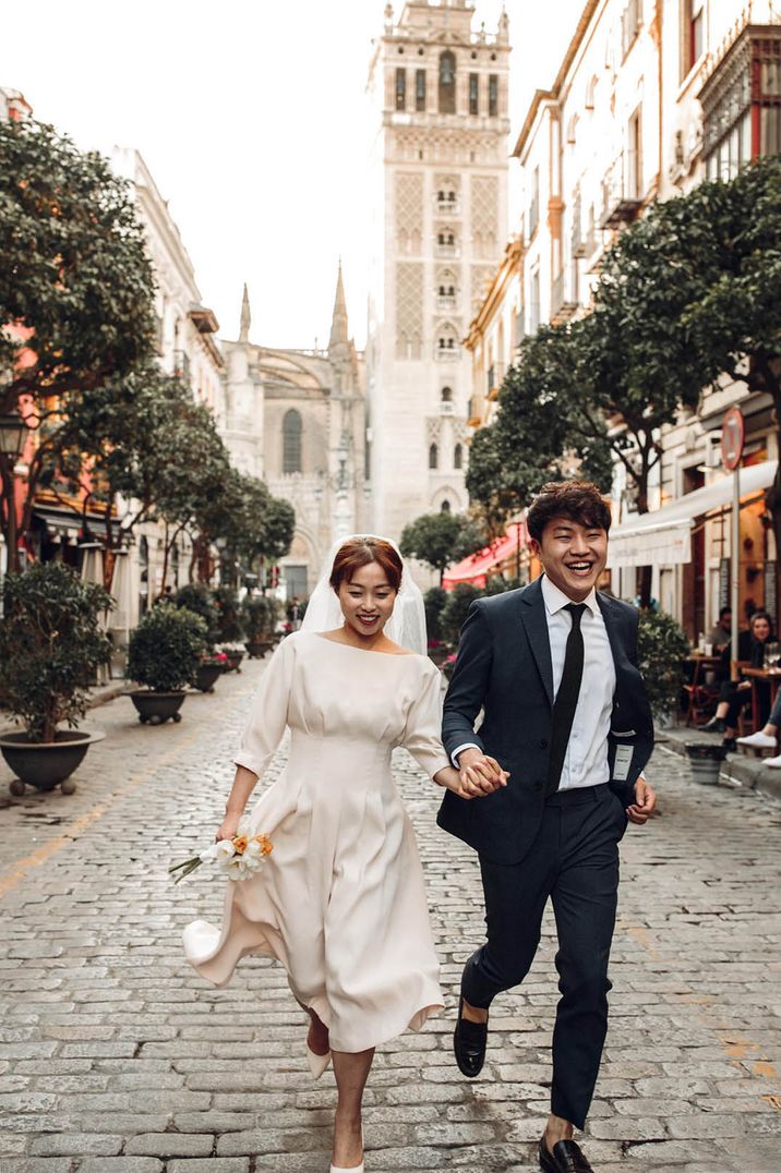 Engaged couple walk around the city of Seville together 