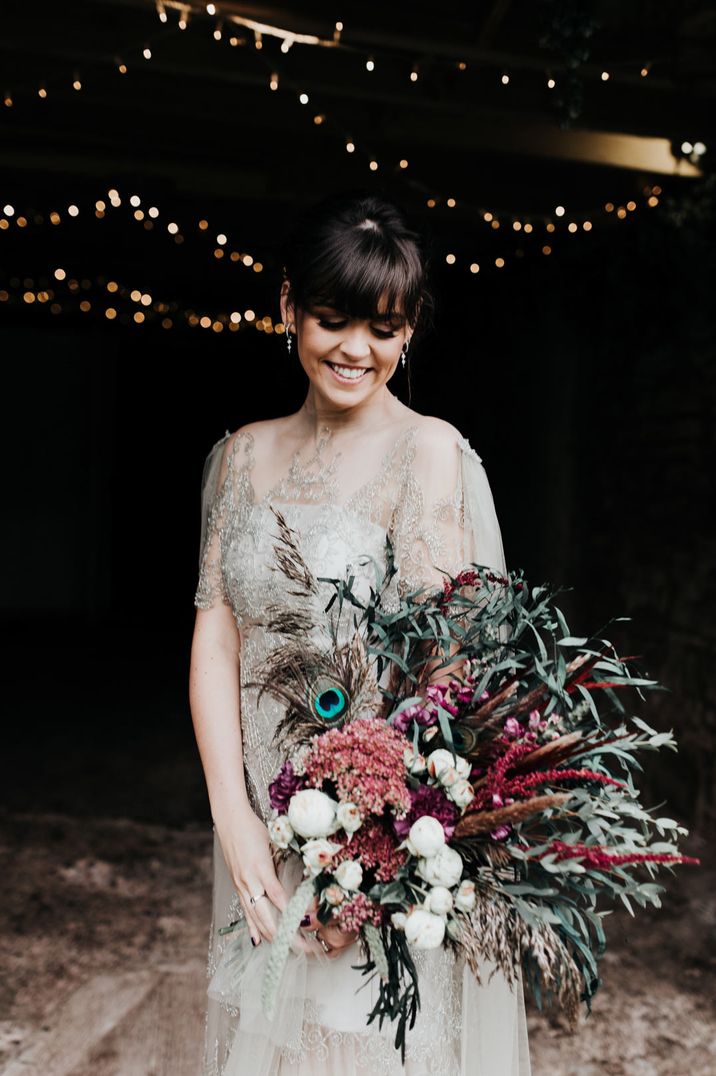 Homemade sage tinted quarter length sleeve wedding dress with homemade bouquet and peacock feathers