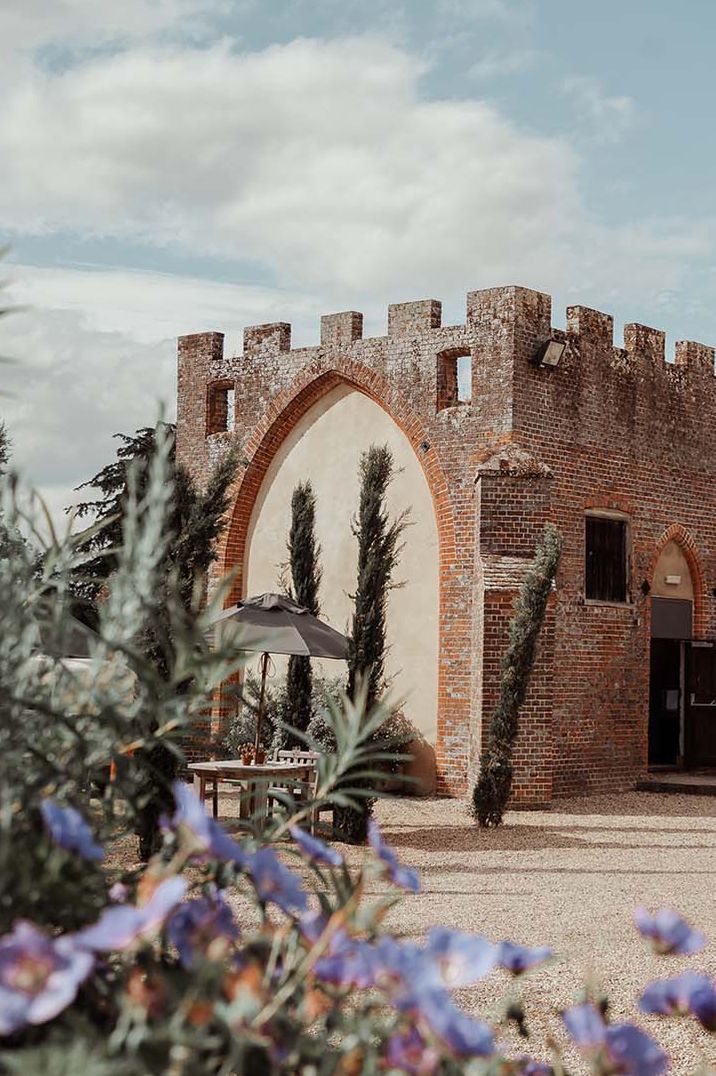 The exterior of Wasing Park country house wedding venue with tones of purple and orange and a piece of lavender in frame