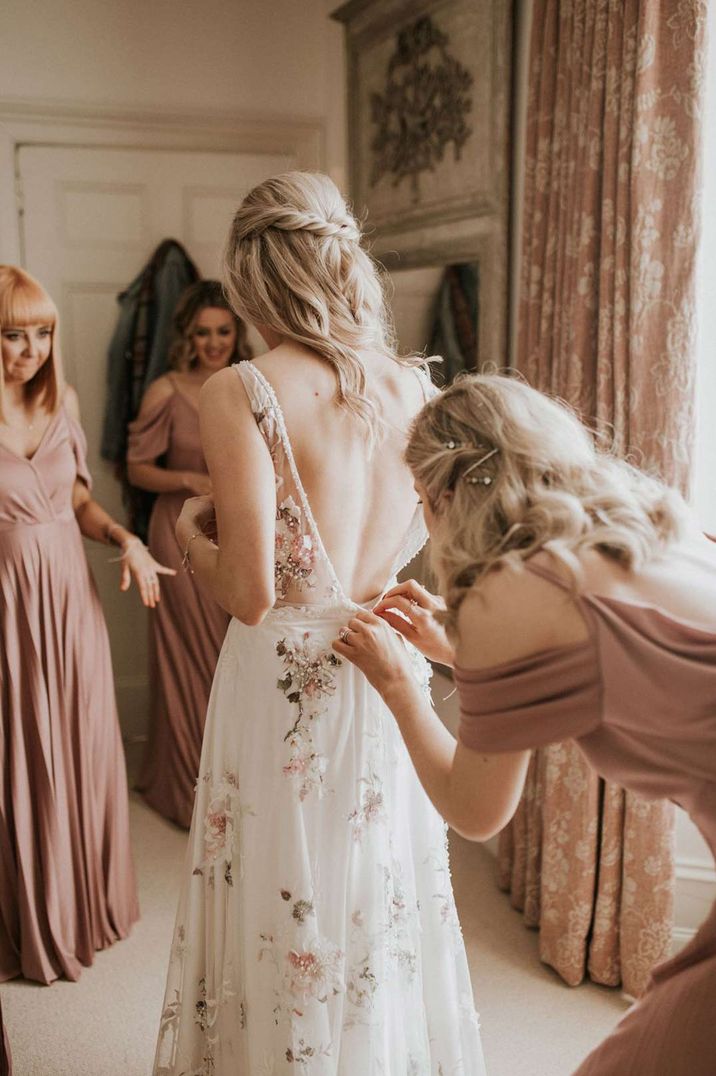 Bride getting ready in her floral embroidered wedding dress with low back 