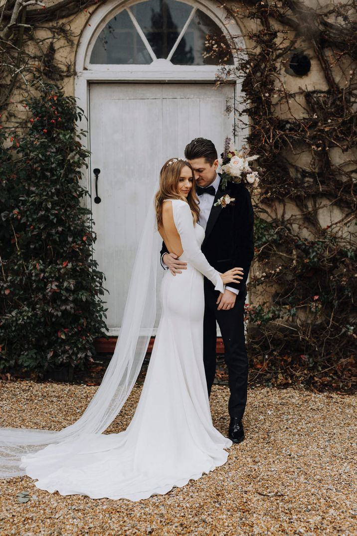 Black tie winter wedding with bride in an Emma Beaumont wedding dress with plain long sleeves