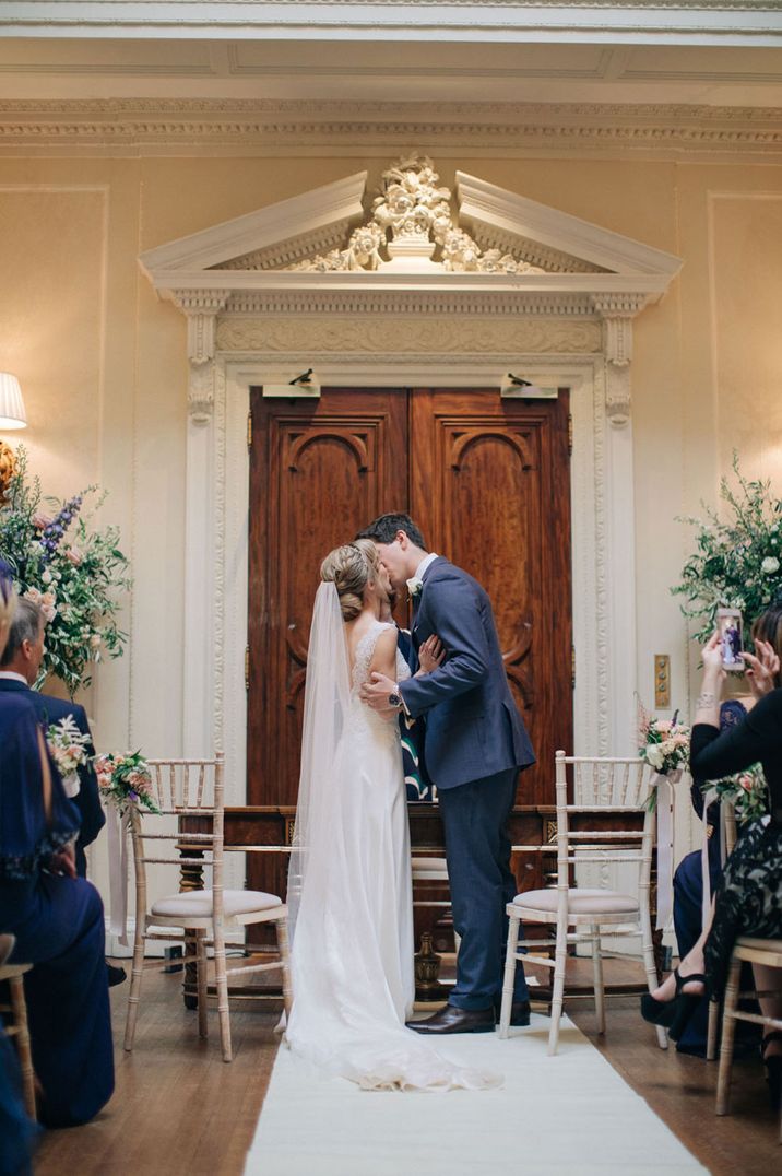 Newlyweds kissing in Hedsor Hall