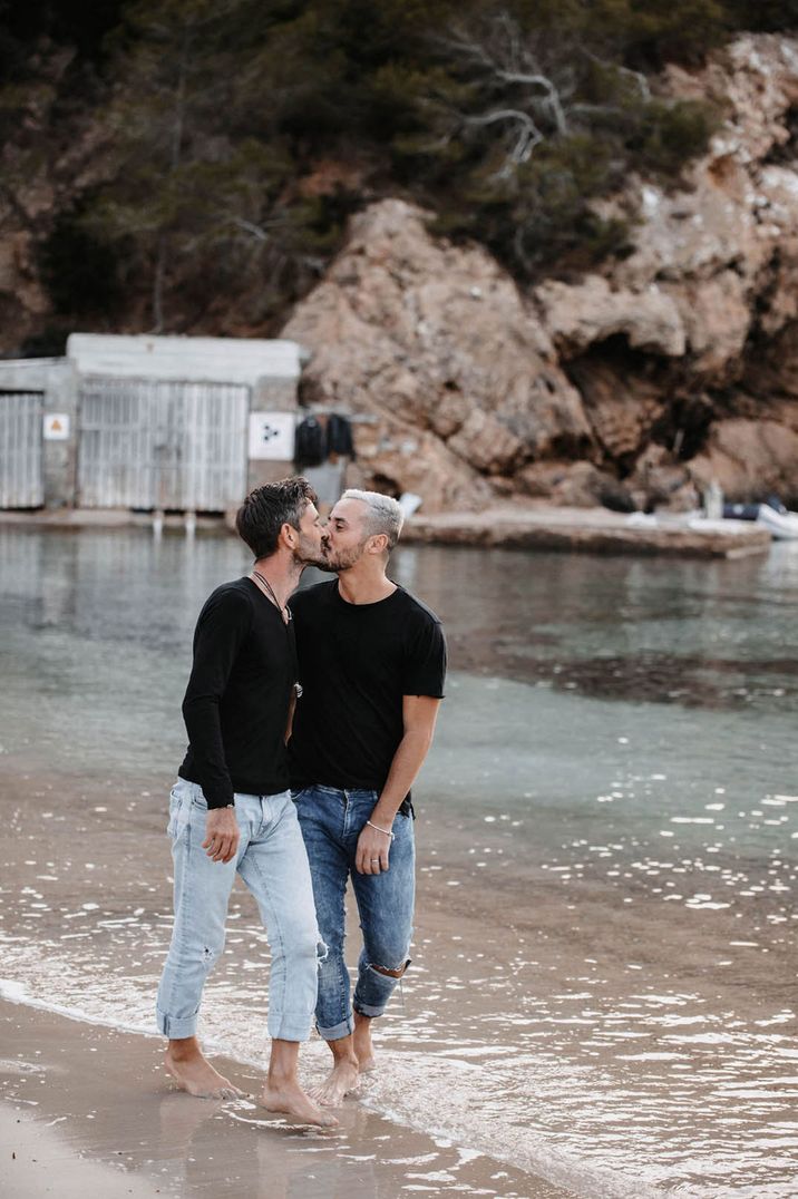 Couple kiss in black tops and jeans on a beach 