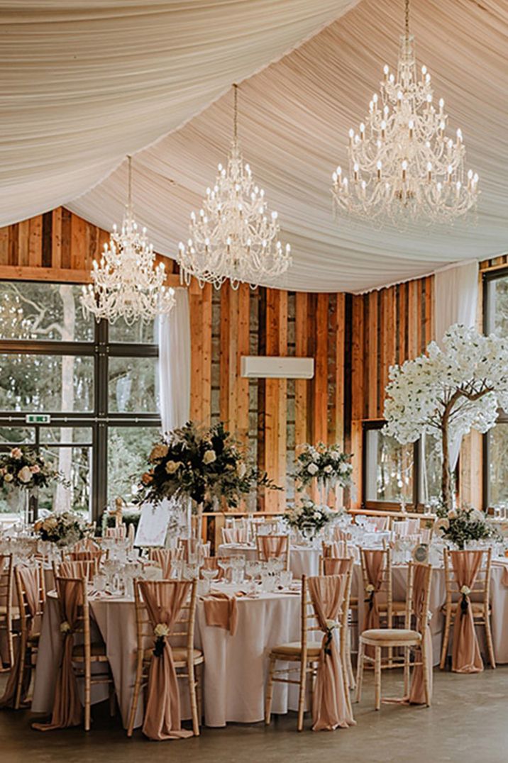 Bunny Hill Weddings in Yorkshire featuring a blush pink tablescape with white drapery, white rose table centrepieces and more 