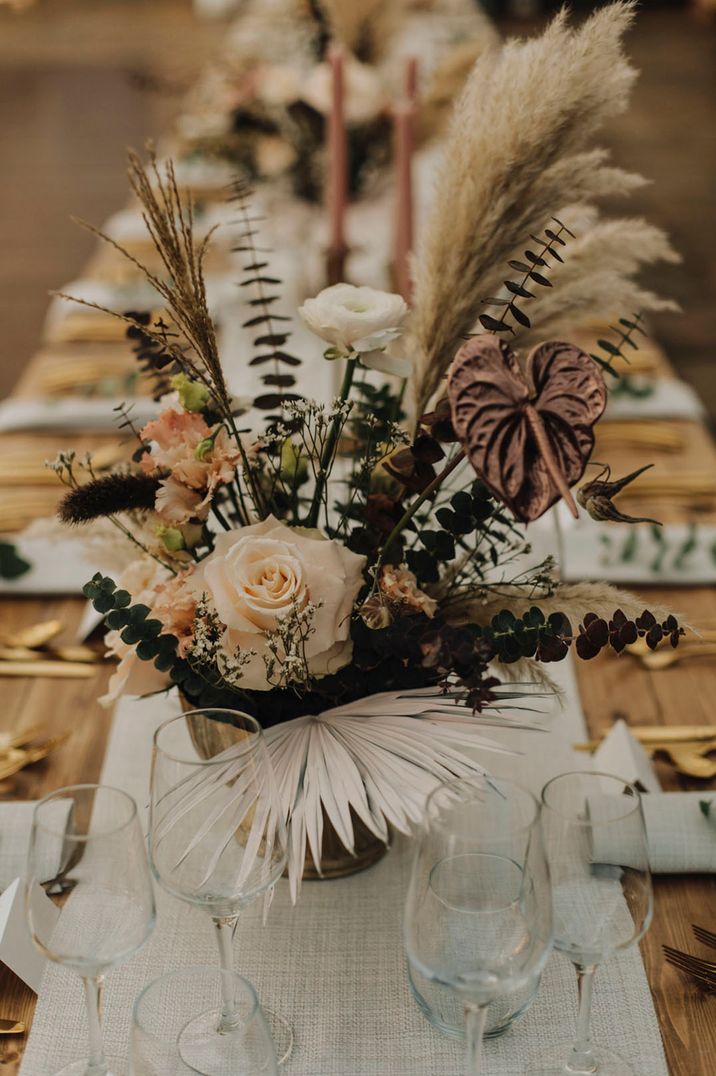 Winter wedding flower table arrangement with neutral wedding flowers including anthuriums, roses and pampas grass 