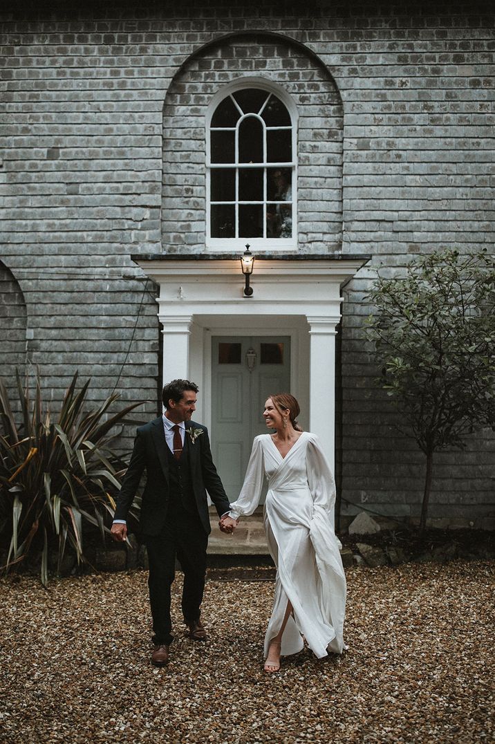 Bride in floaty wedding dress with groom at their country house wedding venue 