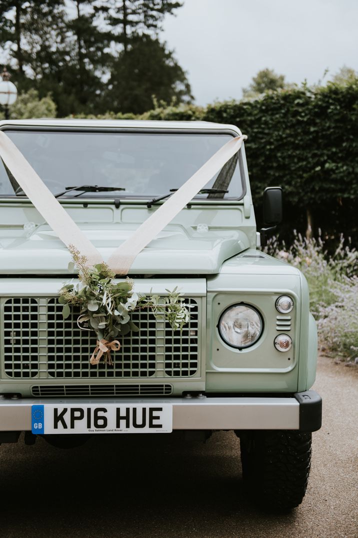 Land Rover wedding car with white ribbon and flower decoration