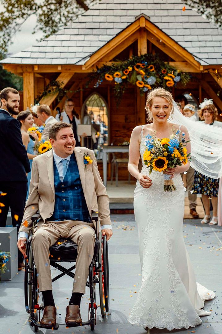 Bride and groom doing sunflower confetti walk at Southend Barns, one of the best barn wedding venues