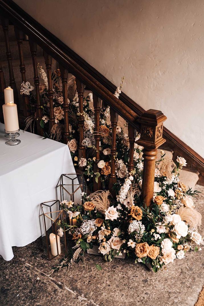 Neutral toned rose and foliage display on the staircase of Pennard House