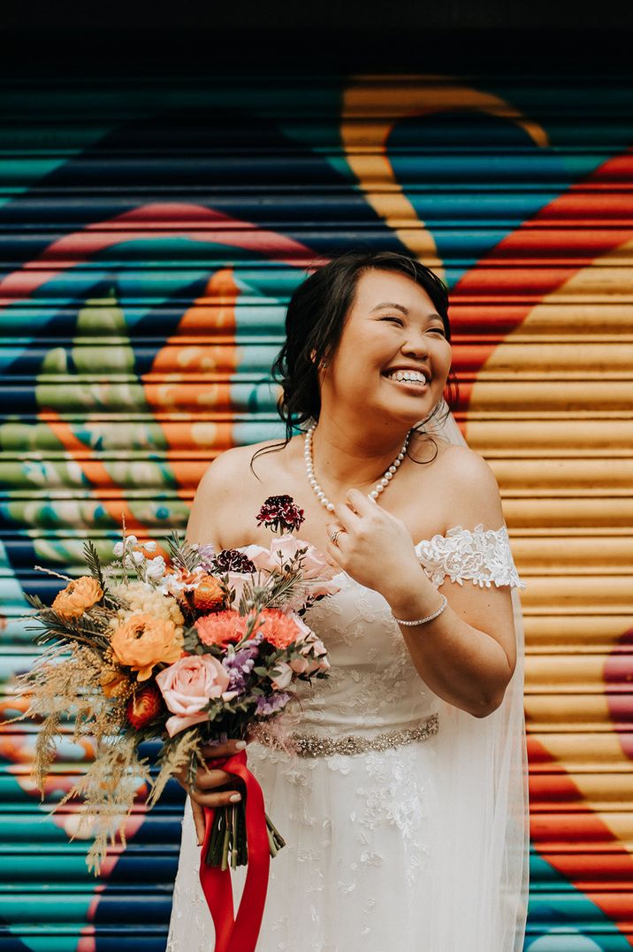 Bride wears embellished bridal belt and pearl necklace