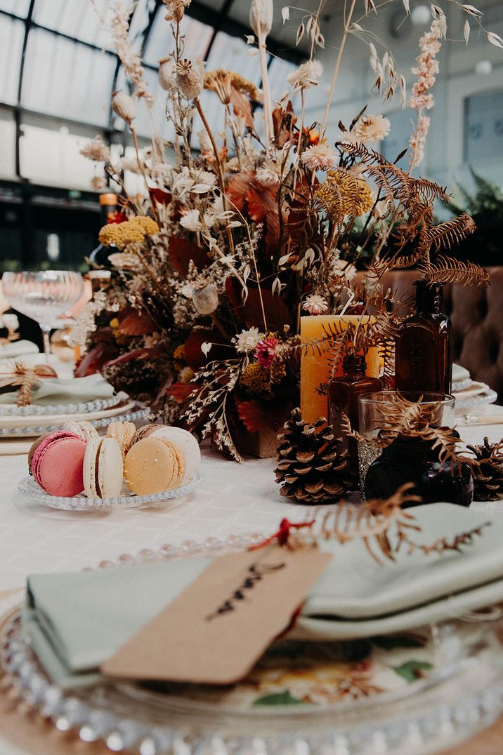 Cotton, dried wedding grasses, autumn leaves, for long table centrepiece with plate of colourful macarons 