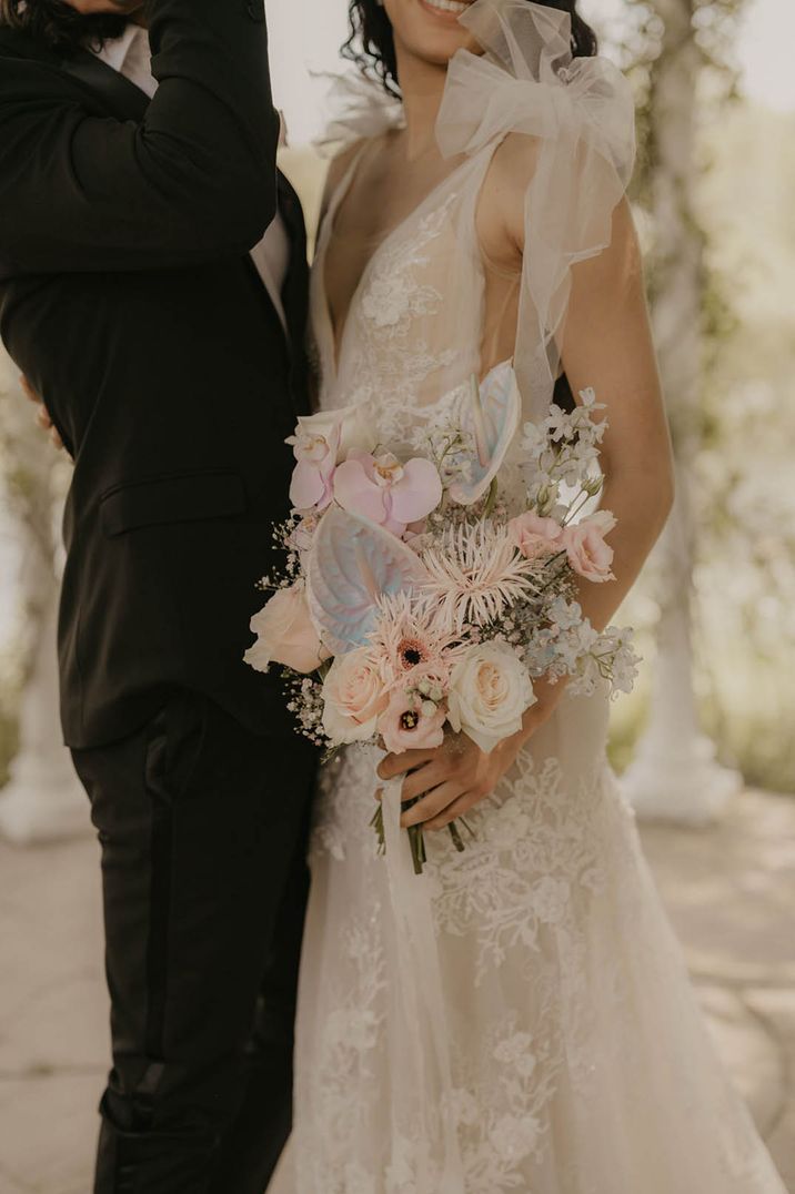 Pink orchids, pastel anthuriums, and pale pink rose wedding bouquet 