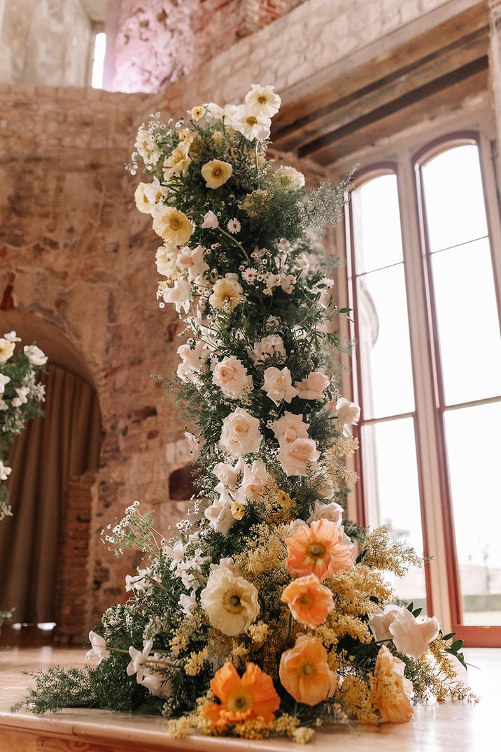 Stunning wedding flower column with poppies, the birth flower of August 