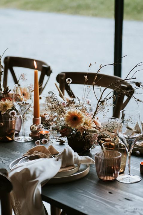 Wedding tablescape with dried flowers, orange candles and neutral napkins