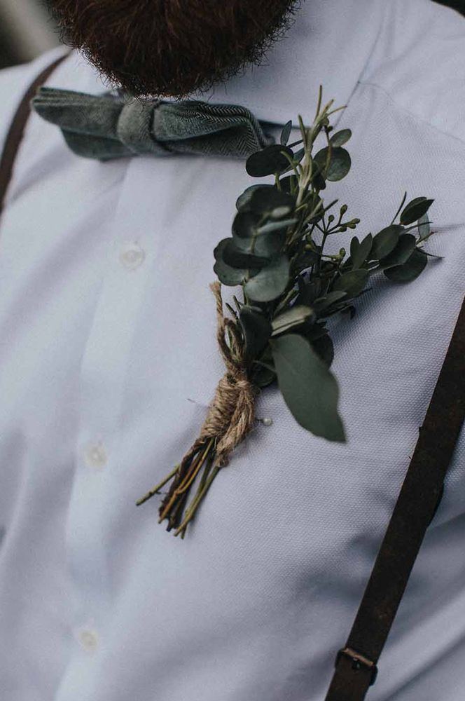 Groomsman in a white shirt, braces and bow tie with foliage buttonhole