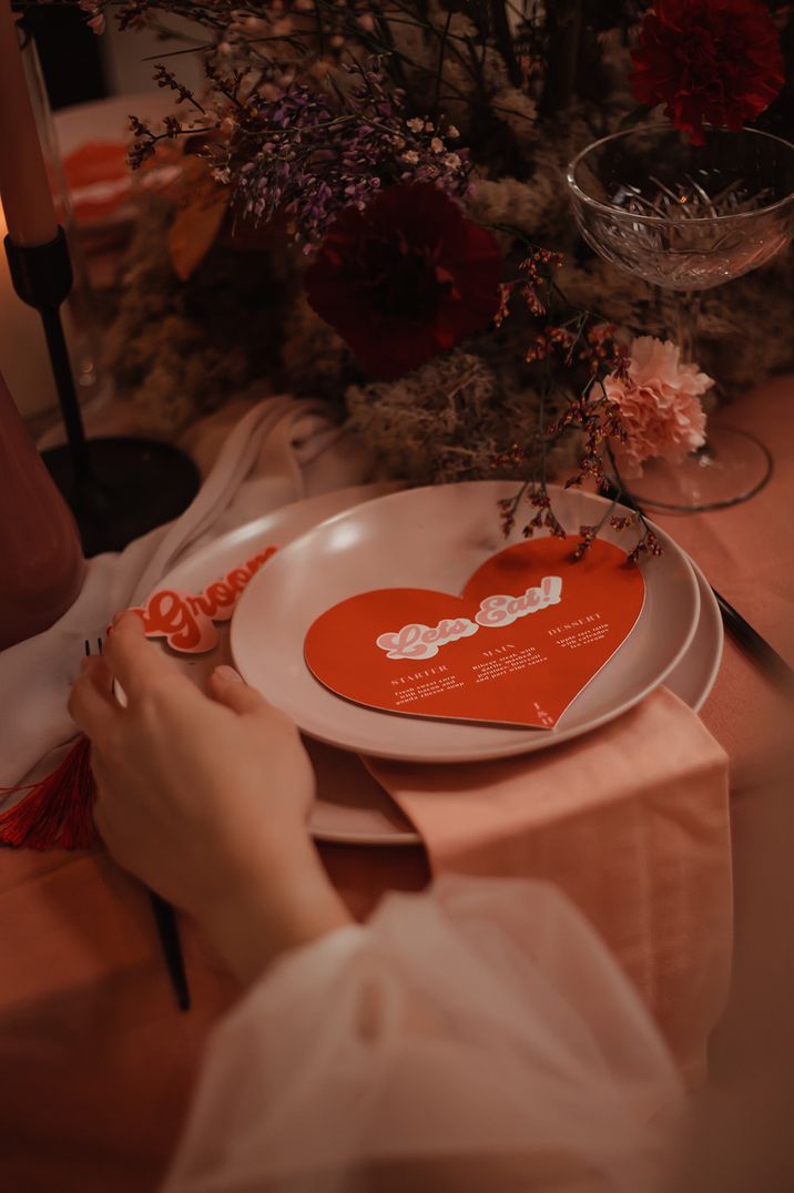 Valentine's Day wedding ideas with a heart shaped wedding menu sitting on the plates 