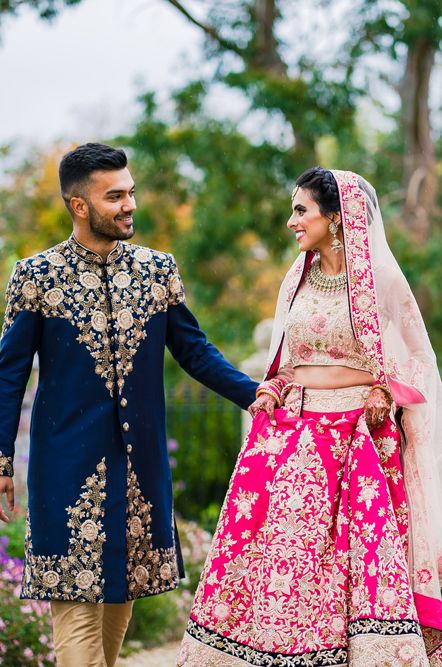 Brightly coloured Hindu fusion wedding at Elmore court with bride in a pink wedding dress and groom in a navy blue and gold suit