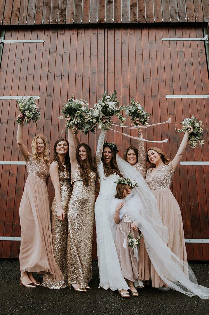 boho wedding with bridal party in flower crowns and different sparkly rose gold and gold bridesmaid dresses 