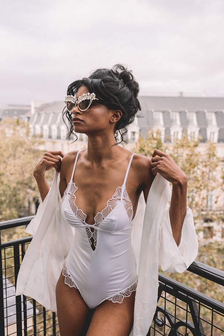 Bride wears white bodysuit with lace edging