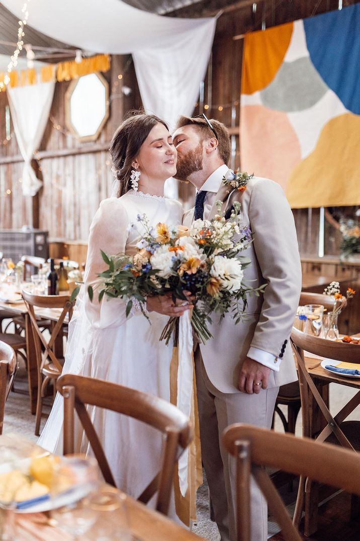 Deepdale Farm DIY wedding with bride in a vintage wedding dress holding a yellow and white flower bouquet 