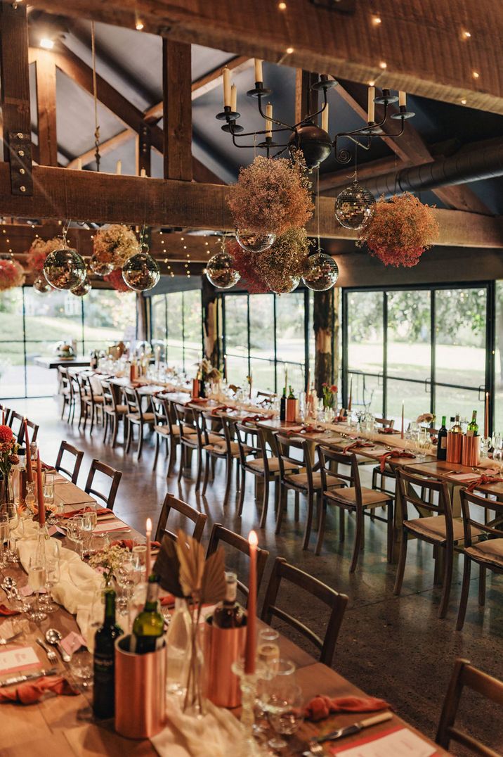 Disco balls and pink gypsophila clouds decorating Dewsall Court wedding venue 