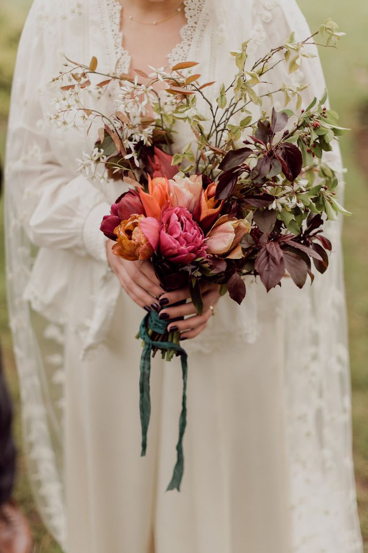 Deep red wedding bouquet with green red foliage leaves