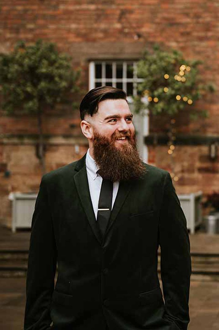 Groom in jet black suit and black tie