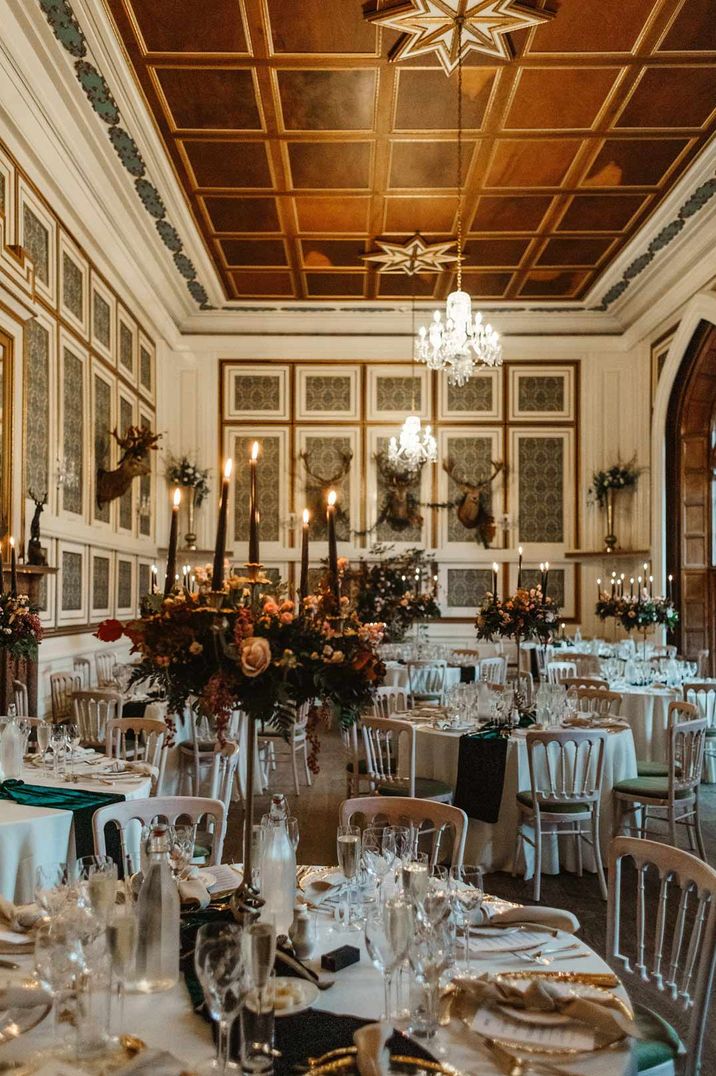 Wedding tablescapes with black candles and rose wedding flower centrepieces with white napkins and plates with gold details