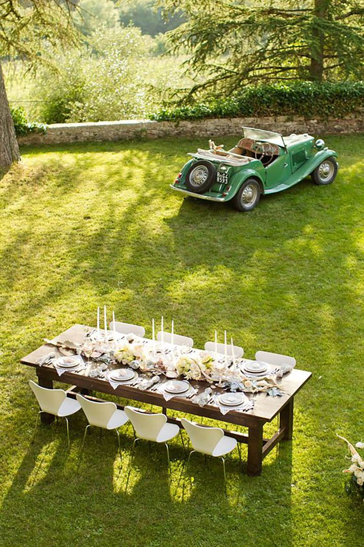 Italian vineyeard with grassy green setting, table set up and vintage car by Mike Larson Photography