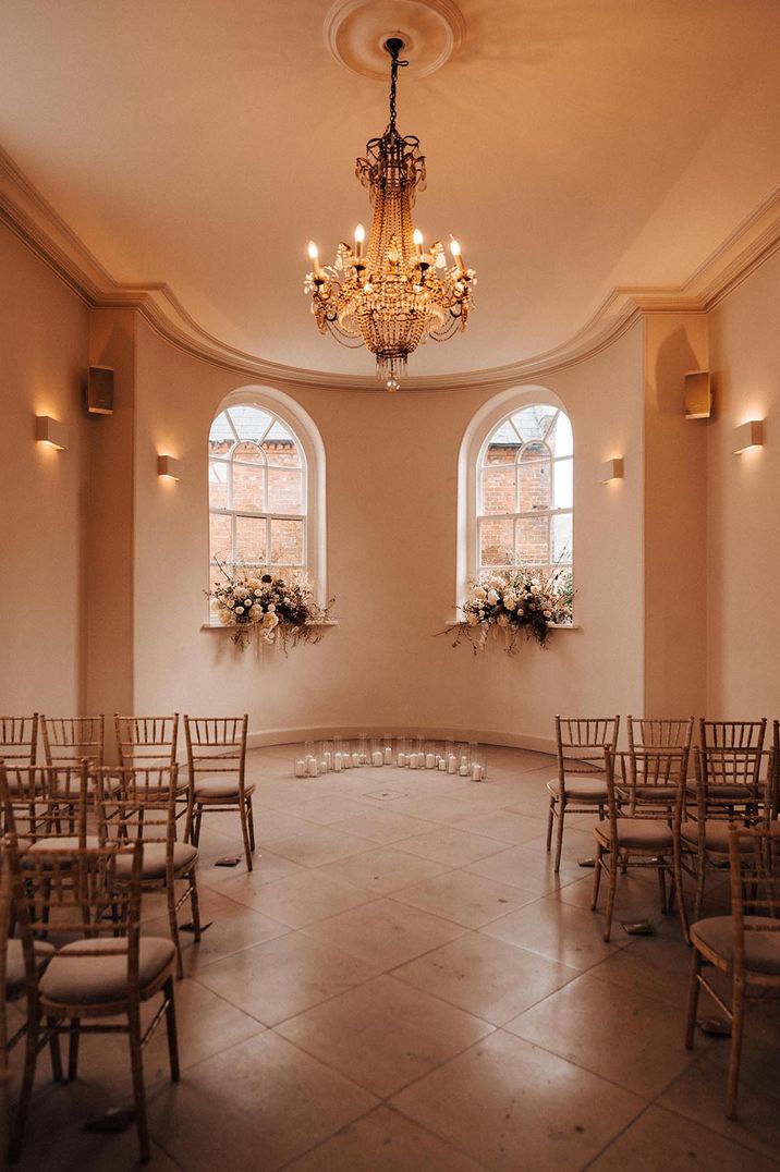 Reception room at Iscoyd Park with large chandelier and white rose floral arrangements